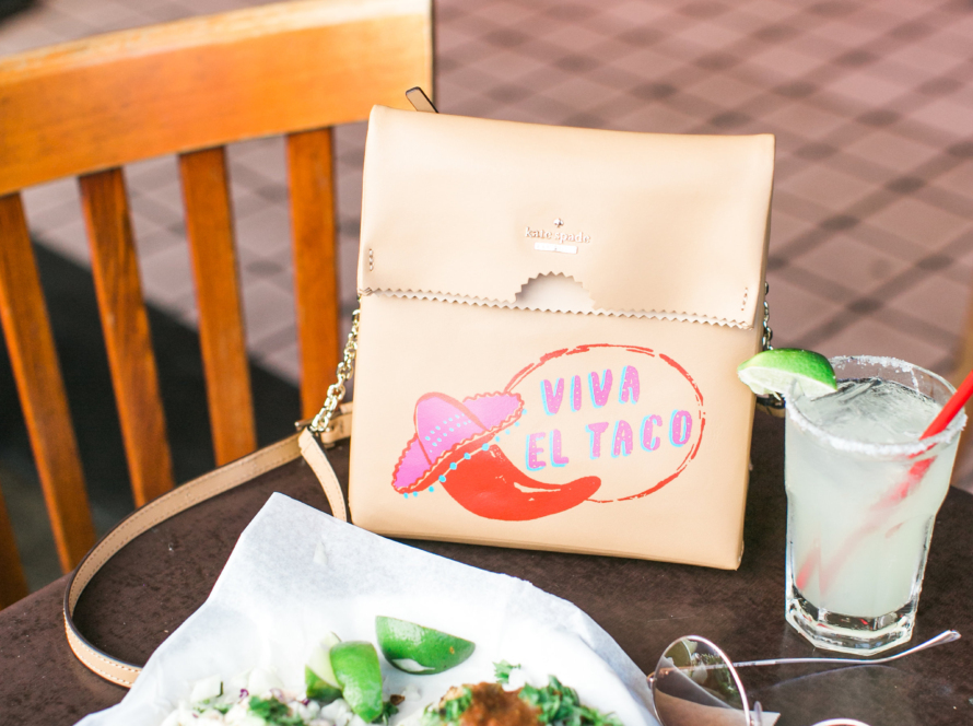 We can see in the image a table of a thematic space, a mojito-style drink, sunglasses, a small pink women's handbag with a logo that has a chili with a Mexican hat and a legend that says "long live the taco", finally we see what appears to be the remains of a typical food dish.