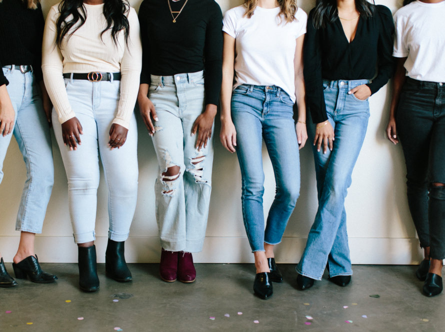 We can see in the image six women side by side, without focusing on their faces. The six have different physical builds, they are dressed in a t-shirt, jeans and shoes, all with different styles. One last detail, they intersperse black and white shirts.